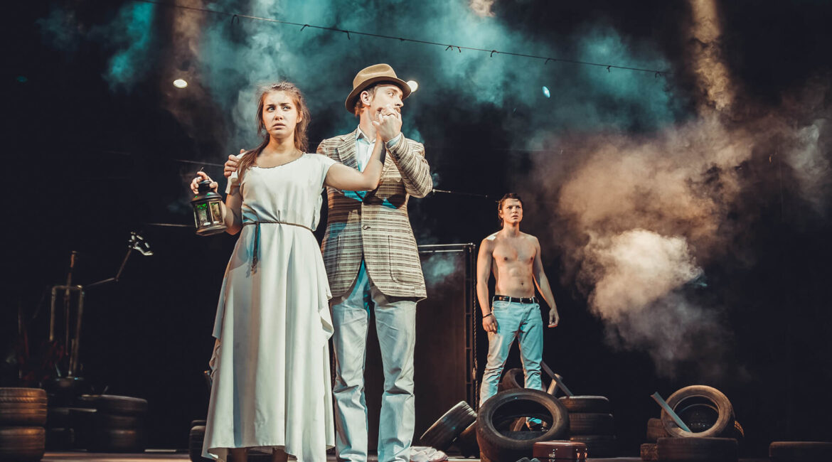 Two men and a woman on the stage of the theater